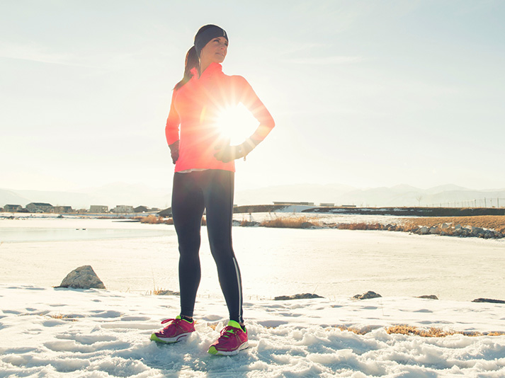 Sportieve collega met een activitietstracker als praktisch kerstcadeau, buiten in de sneeuw